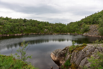 Fototapeta na wymiar Mountain lake on the side of the tourist route to Preikestolen rock. Norway