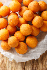 Thai fried sweet potato dough balls closeup on the wooden table. Vertical top view from above