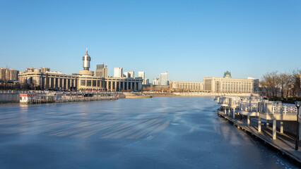 Frozen Hai river (Haihe) in central Tianjin, with Tianjin railway station, China