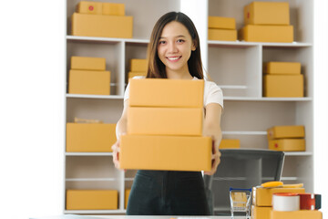 Confident Asian china people SME owner diligently packing products into boxes, epitomizing the...