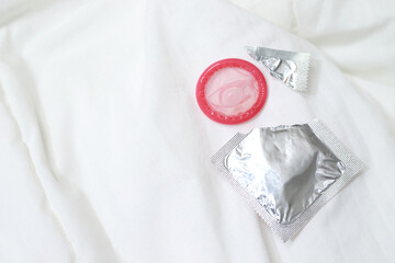 Condom ready to use in female hand, give condom safe sex concept on the bed Prevent infection and...