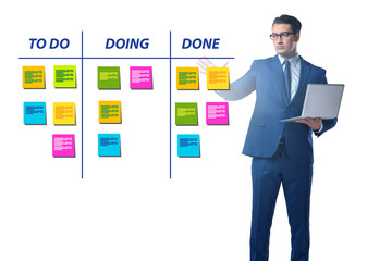 Businessman working on kanban board with tasks