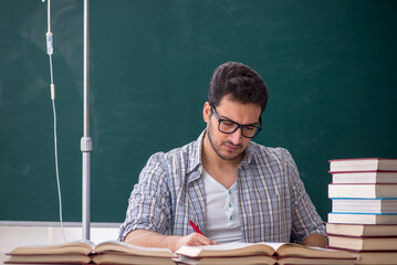 Young male teacher suffering in the classroom