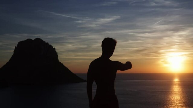 Views from a viewpoint with an island in front. Man pointing to the sunset