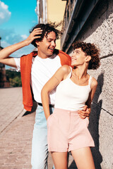 Naklejka premium Young smiling beautiful woman and her handsome boyfriend in casual summer white t-shirt and jeans clothes. Happy cheerful family. Female having fun. Couple posing in the street background