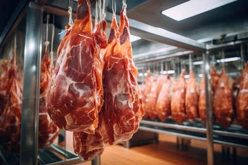 Fotobehang Meat processing plant. Raised meat for further processing in the production hall. The arrival of jamon or cold cuts. Natural fresh meat product. Production of pork or beef in a modern enterprise. © Anoo