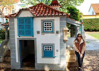 Miniature house. Miniature city in village Little Portugal. A girl in a small house.