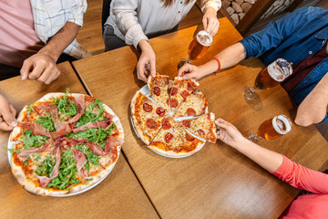 leisure, food and drinks, people and holidays concept - close up of friends eating pizza and...