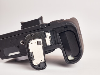 The digital mirrorless camera is shown below with the battery compartment open. Power supply of...