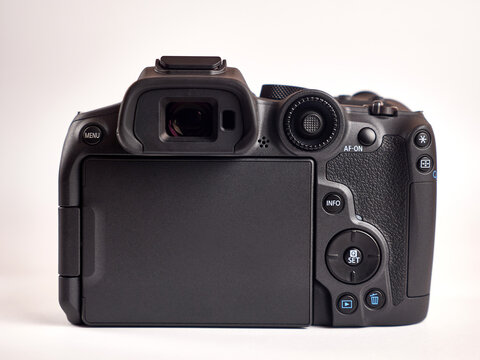 A mirrorless digital camera is depicted on the side of the monitor. Modern photo equipment.