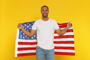 4th of July - Independence Day of USA. Happy man with American flag on yellow background
