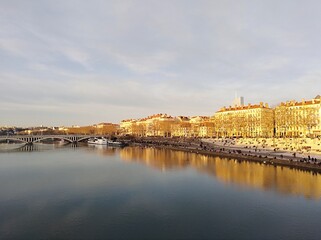 Fototapeta premium the banks of the Saône, the reflection in the water of the buildings and the bridge which spans the river, in Lyon. France 