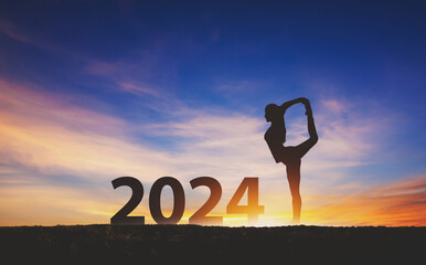 New year 2024 fitness healthy woman yoga with sunset sky background - 655177757