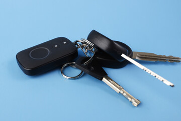 car alarm remote control and car keys on a blue background