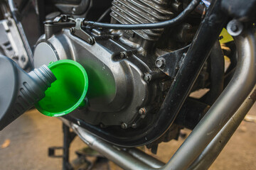 pouring new motor oil into a motorcycle engine