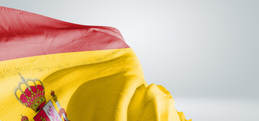 Spain national flag cloth fabric waving on beautiful sky Background.