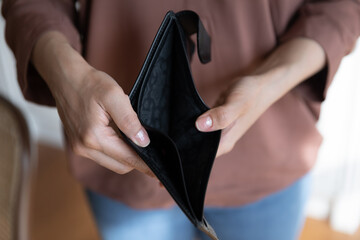 Crop close up of Indian woman holding empty leather wallet in hands, poor young female having...