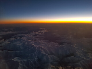 Flight Over Snowy Mountains and the lovely shine of Sunset in Altitude