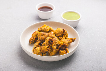 cauliflower fritters with sweet and sour chutney, served hot on a white plate