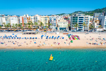 Resort town on the Mediterranean coast in Spain. Drone view of the main beach in the town Lloret de Mar, Girona  Spain  - obrazy, fototapety, plakaty