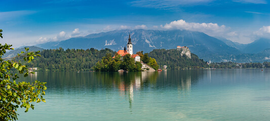 Lake Bled (Blejsko jezero) Slovenia. Beautiful mountain lake with small Pilgrimage Church. Most famous Slovenian lake and island Bled with Pilgrimage Church of the Assumption of Maria and Bled Castle  - obrazy, fototapety, plakaty