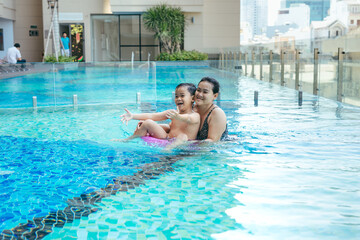 Mother and son having a great time in the pool.