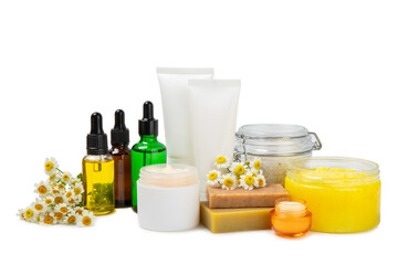 Chamomile spa. Composition with chamomile flowers, handmade soap, essential oil cosmetic bottle, body cream, scrub and sea salt isolated on white background. Relaxing beauty treatments.