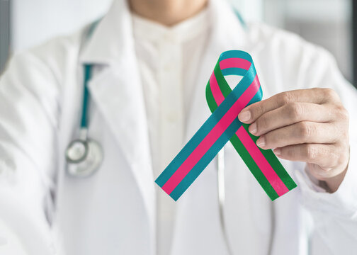 Metastatic Breast Cancer (MBC) awareness with pink teal green ribbon in doctor's hand for October wearing pink day charity for woman fighting with breast tumor illness - Powered by Adobe
