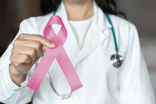 Breast cancer awareness pink ribbon raising awareness on woman health and female illness in October month with bow color on female doctor gown in clinic or hospital