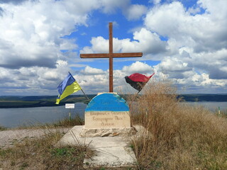 A monument to the heroes of the liberation struggle of the Ukrainian insurgent army against the background of the rapid flow of the Dniester on the horizon.