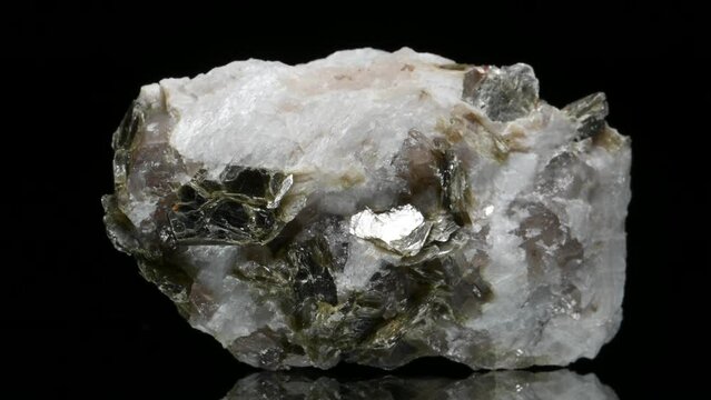 Muscovite (mica  sample rotating slowly against a black background.