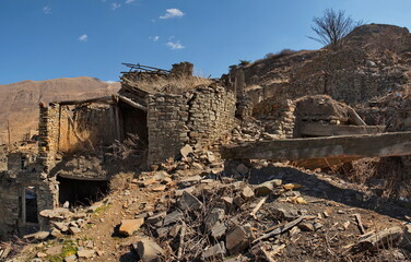 Russia. North-Eastern Caucasus,  Dagestan. View of the Caucasus Mountains through the doorway of an abandoned house in the mountain village of Khushtada. Traditionally, all houses are made of stone.