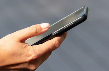 Black smartphone in the hands of a girl. Close-up