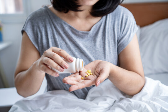 closeup woman hand taking overdose antihistamines pills