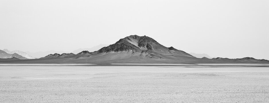 landforms of black mountain peaks which are like moon surfaces. Black and white panorama photo.
