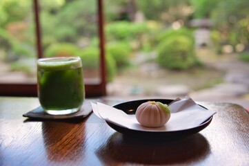 和菓子、冷えた日本の抹茶のある伝統的な古い日本家屋と日本庭園
