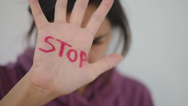 A powerful image depicting the consequences of domestic violence and abuse, showing a woman with visible grazes and beatings on her face, accompanied by the stark word "stop."