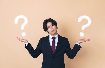 二つのものを比べるスーツを着た若い男性　ビジネスマン