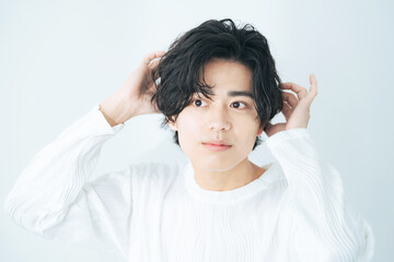 ヘアスタイルを整える若い日本人男性　美容　スキンケア　メンズコスメ