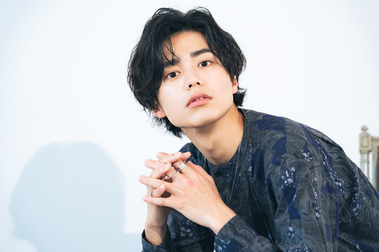 Portrait of young Asian man with green leaves. Men's cosmetics. Beauty salon.