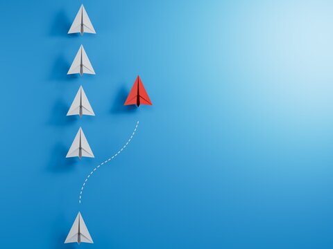 Group of white paper airplane in one direction and one red paper airplane pointing in different way on blue background. Business for innovative solution concept.
