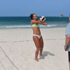 Volleyball player setting the ball on a sunny beach.