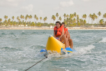 Young people riding inflatable banana boat