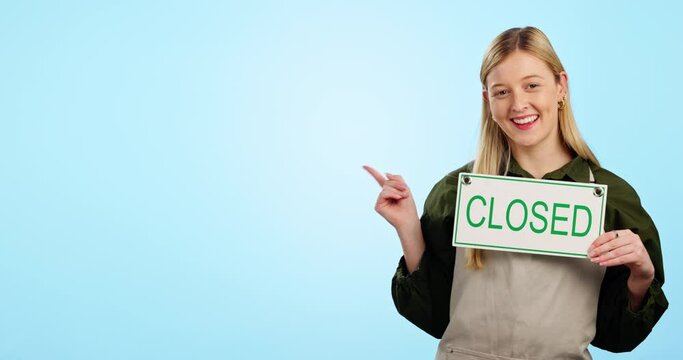 Closed sign, face and sad pointing to shop, retail and business bankruptcy in studio. Mockup space, female entrepreneur and cafe placard with poster to show closure announcement with blue background
