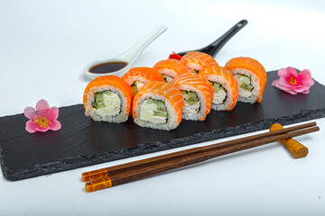 sushi, Philadelphia roll, bowls and chopsticks, on a black plate, slate stand, on a white isolated background