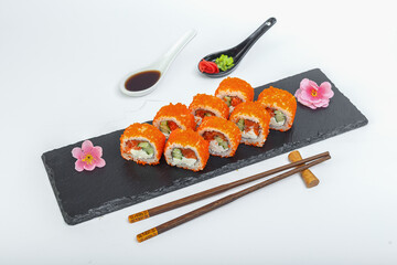 sushi, Roll California salmon, bowls and chopsticks, on a black plate, slate stand, on a white isolated background