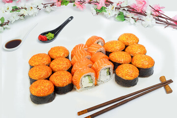 sushi set, a lot of rolls, sakura branch and chopsticks, on a white isolated background © Kurganskiy
