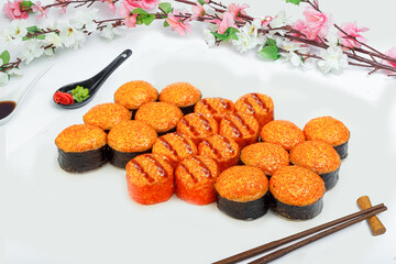 sushi set, a lot of rolls, sakura branch and chopsticks, on a white isolated background © Kurganskiy
