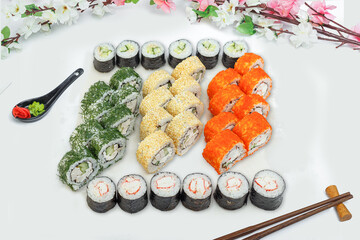sushi set, a lot of rolls, sakura branch and chopsticks, on a white isolated background © Kurganskiy
