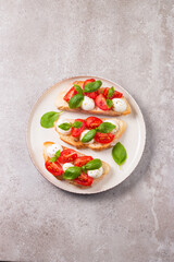 Tomato, basil and mozzarella cheese fresh made caprese bruschetta. Italian tapas, antipasti with vegetables, herbs and oil on grilled ciabatta and baguette bread. Open sandwich.